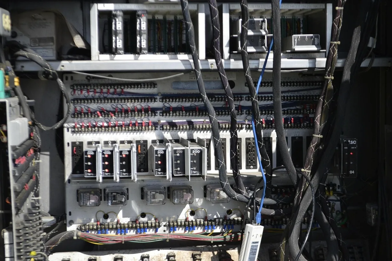 Intérieur d'une armoire électrique industrielle avec câblage et relais