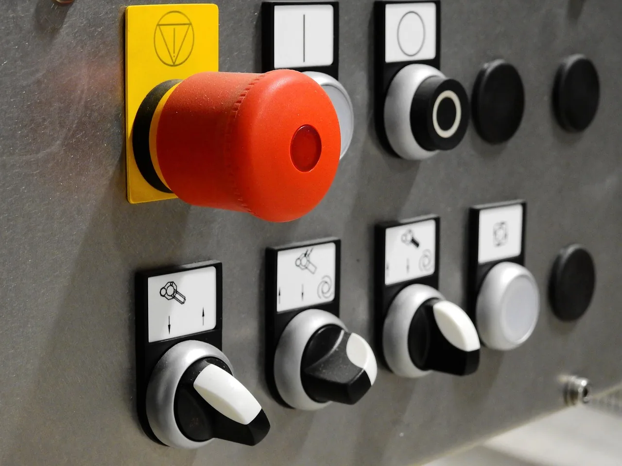 Pupitre de machine avec bouton d'arrêt d'urgence rouge et commutateurs