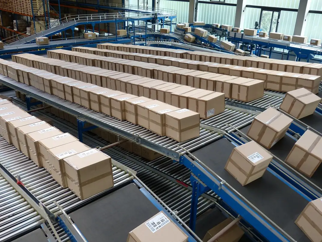 Cartons étiquetés avançant sur des convoyeurs dans un centre logistique