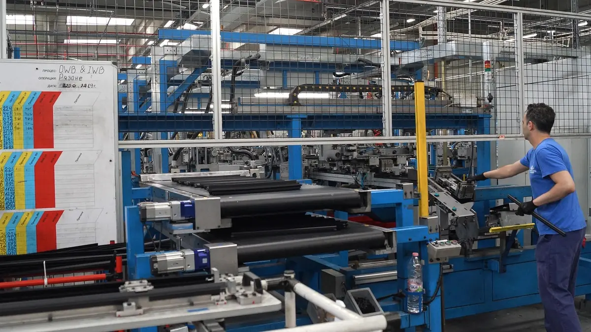 Opérateur sur une ligne de production de profilés caoutchouc dans une usine