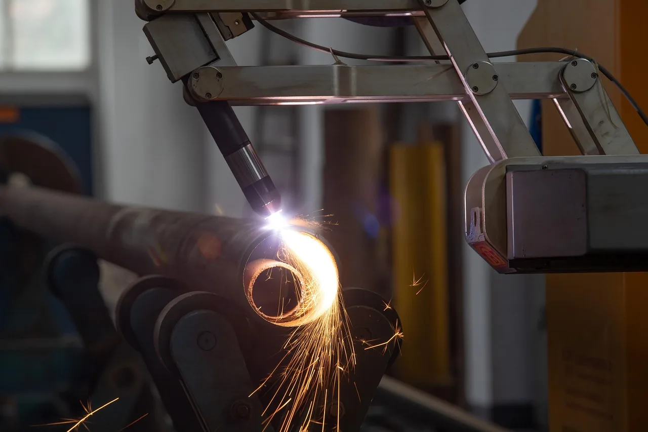 Robot de soudage en action avec étincelles dans une cellule