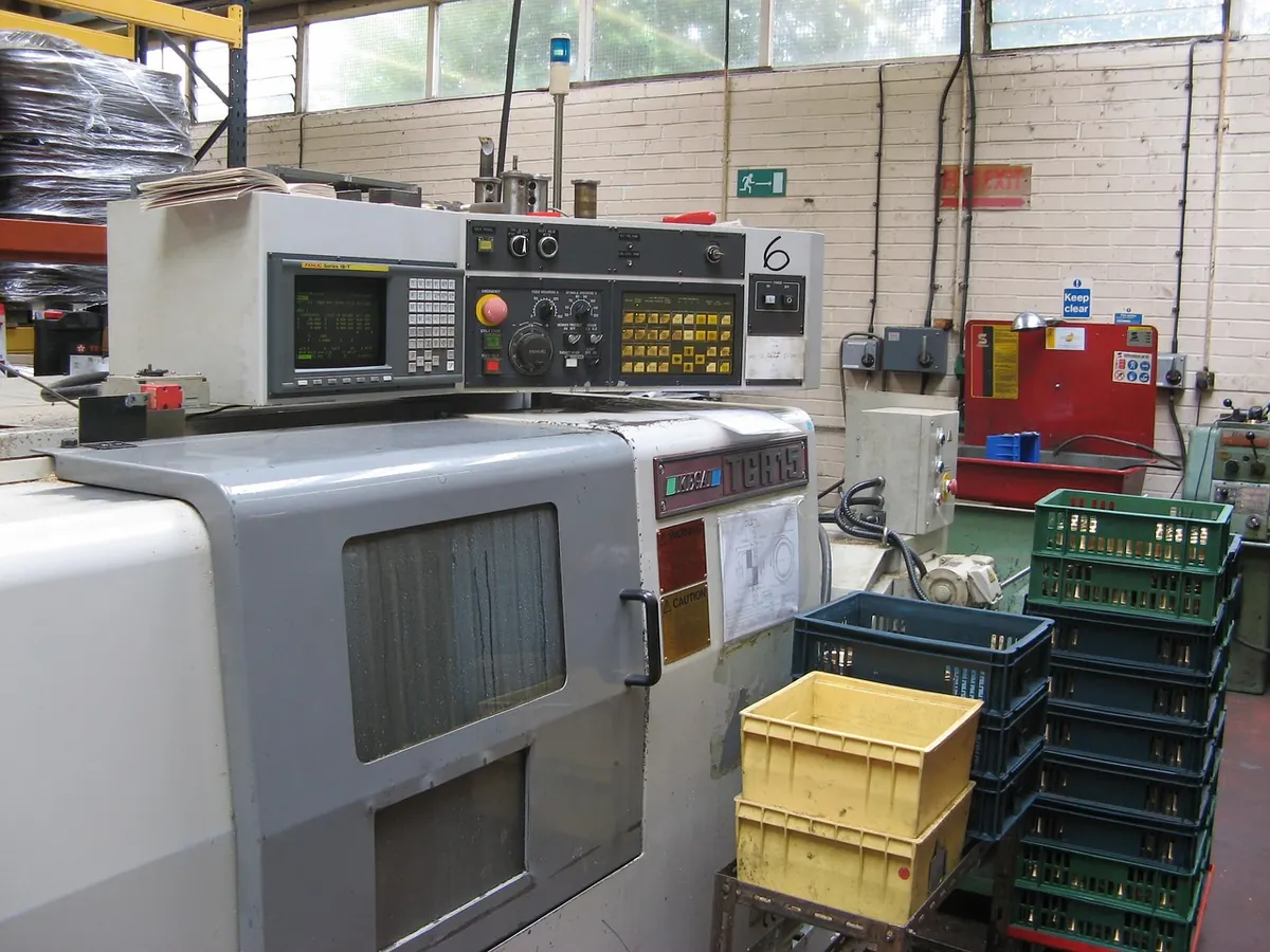 Tour à commande numérique dans un atelier de mécanique avec bacs de pièces